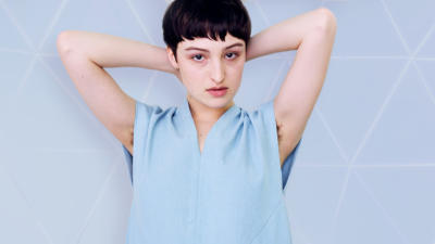 Woman with her hands behind her head with underarm hair